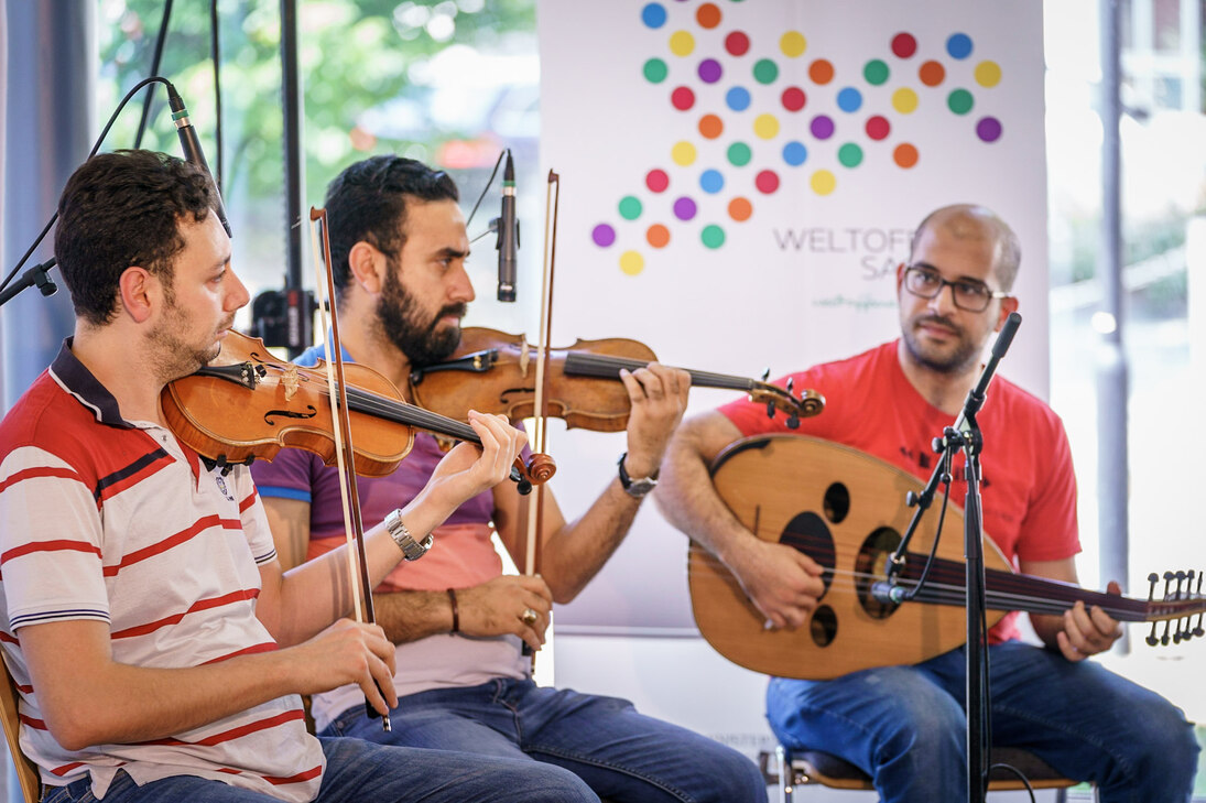 Das Bild zeigt drei der vier jungen Männer des Ensembles »Paradiesisch Musizieren« der Evangelischen Hochschule Dresden mit ihren Instrumenten.