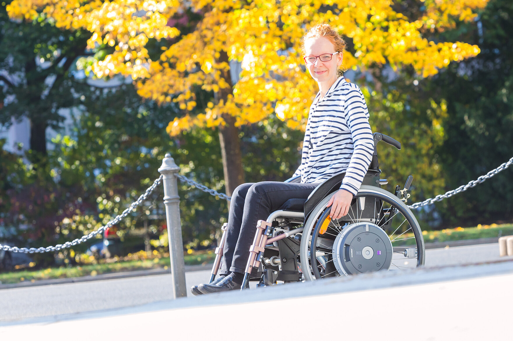 Eine junge Frau im Rollstuhl an der Rollstuhlrampe des Staatsministeriums