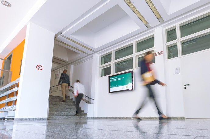 Blick in das Foyer des Staatsministeriums für Soziales und Verbraucherschutz mit drei Personen