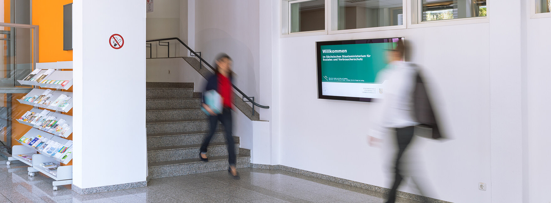 Blick in das Foyer des Sächsischen Staatsministeriums für Soziales und Verbraucherschutz mit zwei Personen