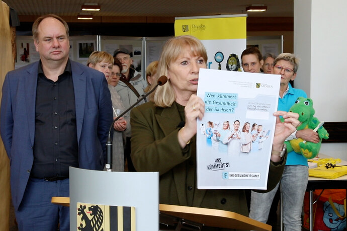 Staatsministerin Petra Köpping hält Kampagnenmotiv nach oben