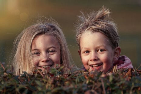 Aufnahme von Geschwisterkindern, die den Betrachter des Bildes anschauen