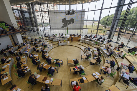 Blick von der Besuchertribüne in den Plenarsaal, in dem die Ministerin am Rednerpult steht und zu den Abgeordneten spricht