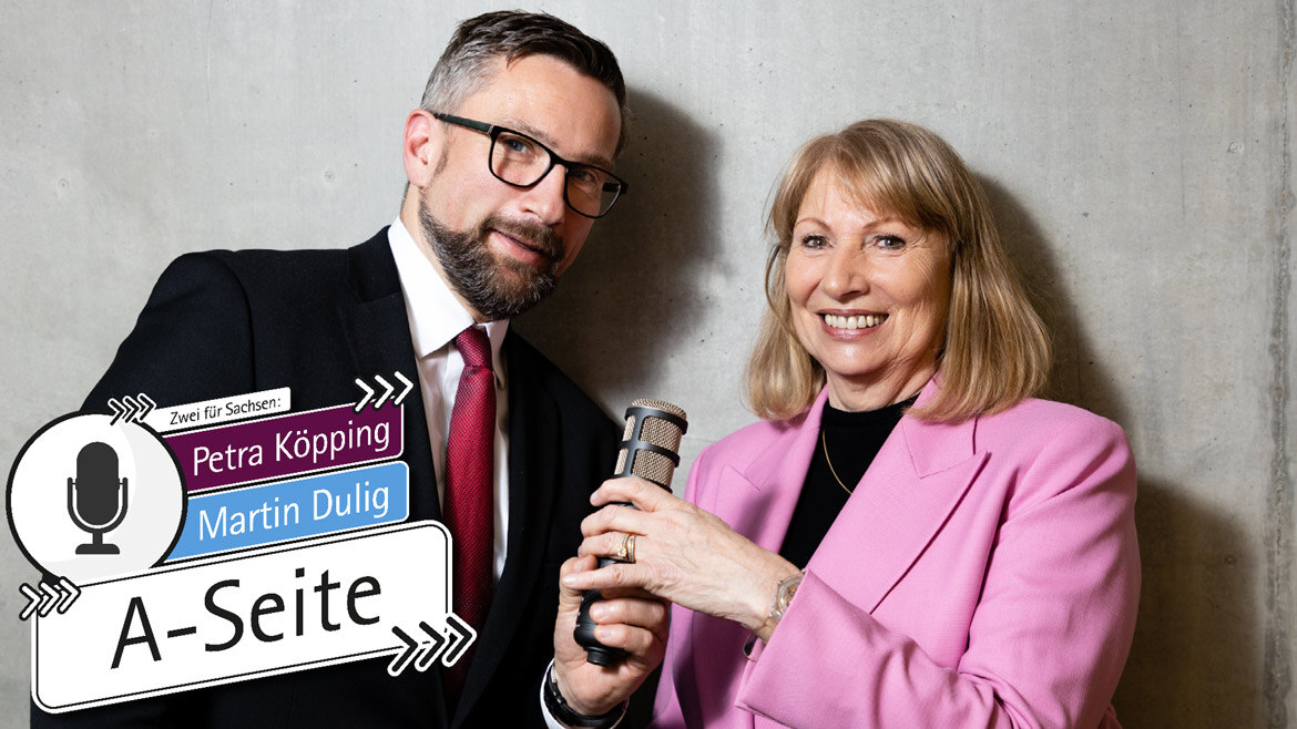 Petra Köpping und Martin Dulig stehen nebeneinander und halten ein Mikrofon in der Hand